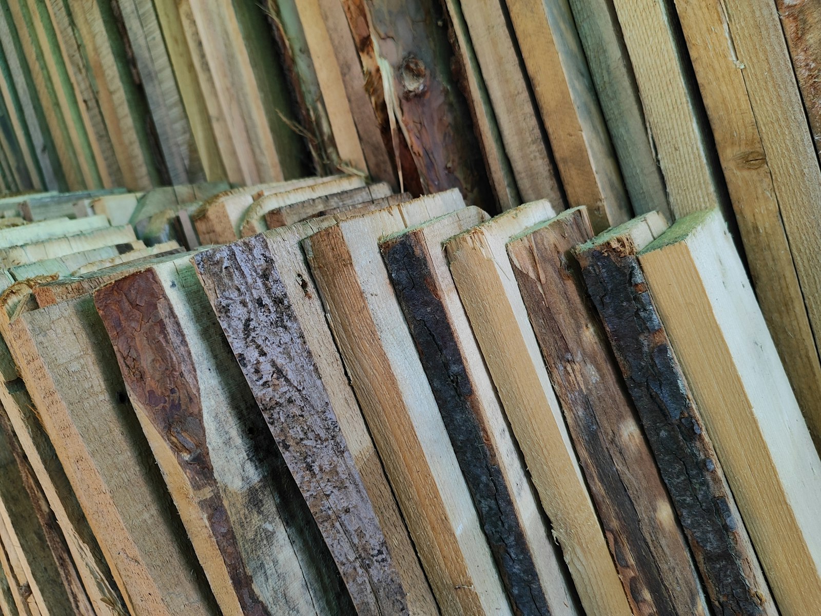 Stack of hardwood lumber boards in varied tones