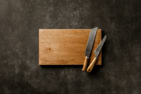 Wooden cutting boards arranged on a kitchen surface with two knives